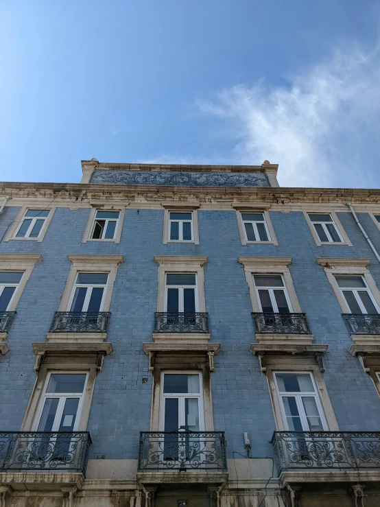 the side of a tall building with a few windows