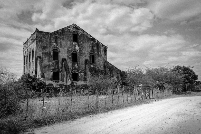 a very large dilapidated building with a tree in front of it