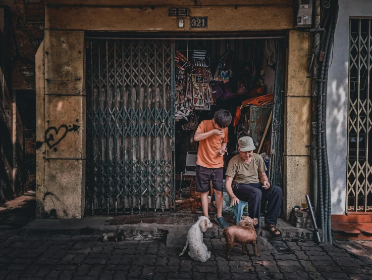 two men on steps with their dogs in front of a door