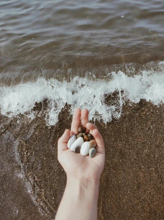a person is holding a small group of pebbles