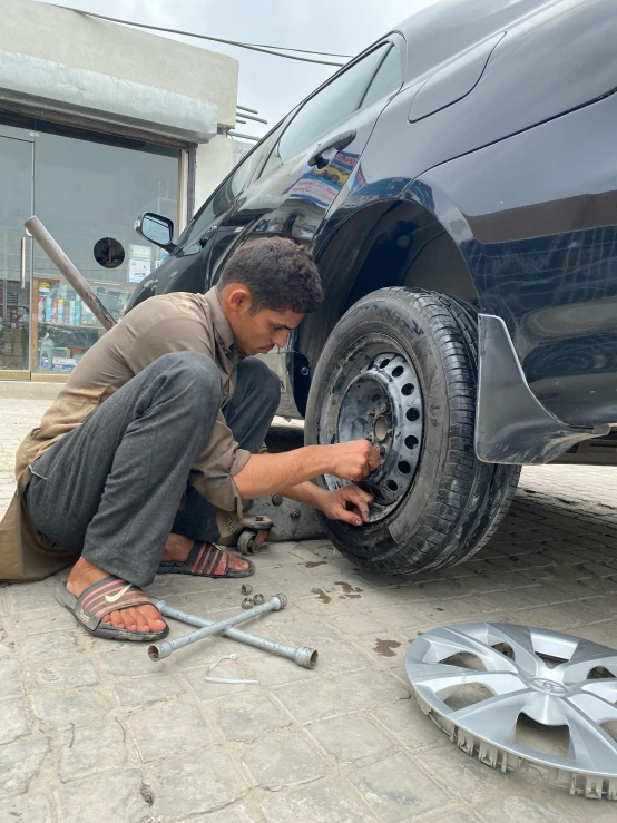 a man working on the tire of a vehicle