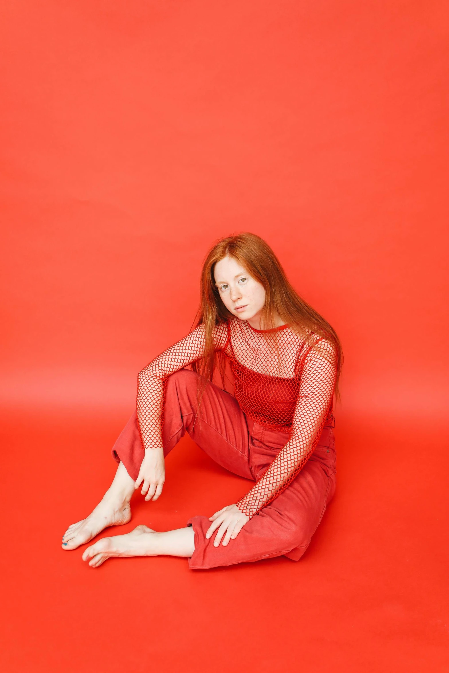 a woman sitting on the ground in red pants