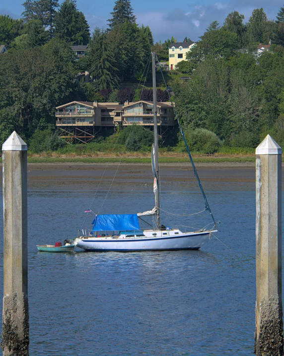 sailboat moored on the lake with houses in background