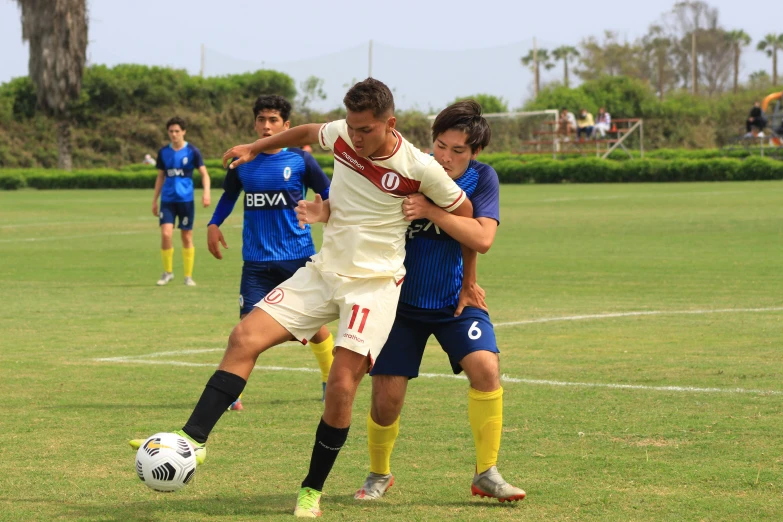 a soccer player on the field being tackled by an opponent