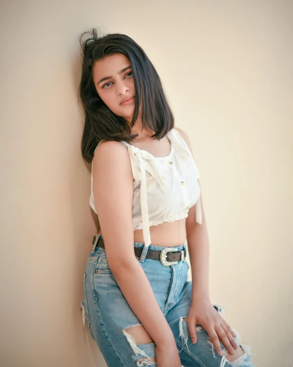 a young woman leaning on the wall and posing for a pograph