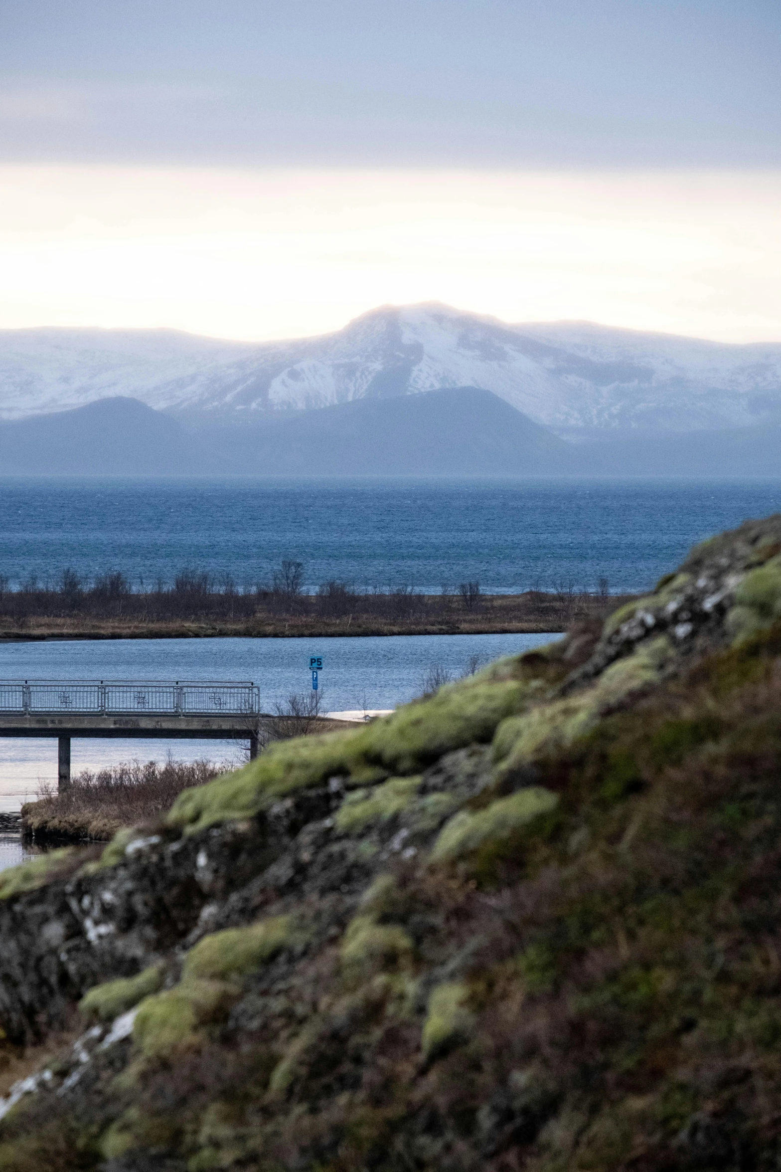 a man is walking on the rocky edge near a lake