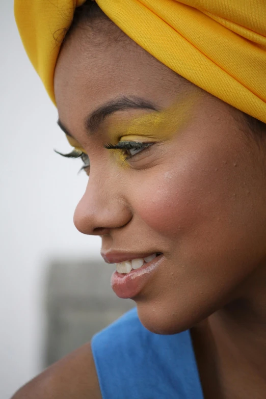 a black girl with bright yellow eyeshadow and blue top