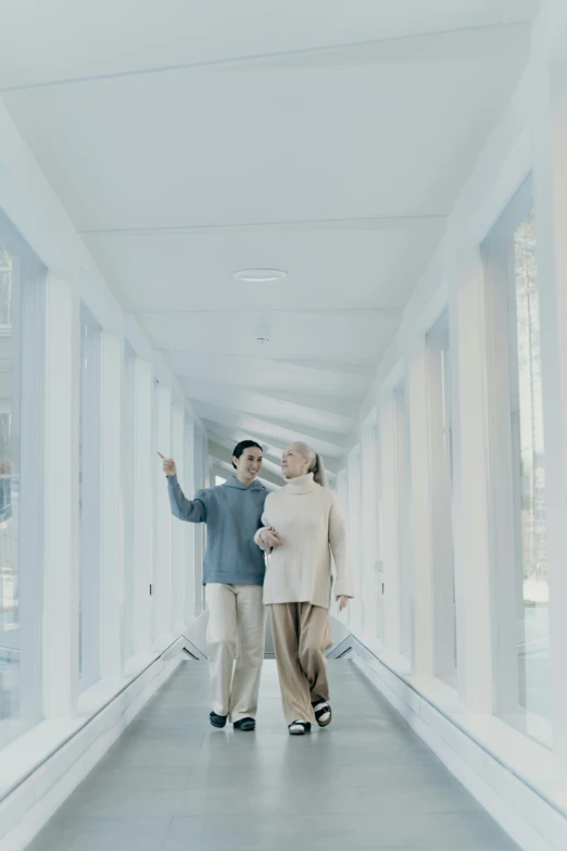 a man and a woman walking on a long hallway