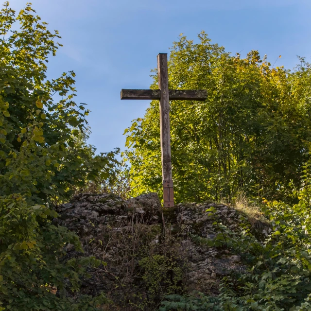 a wooden cross that is by some trees