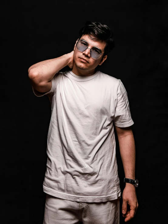 a young man posing for a studio s wearing a white t - shirt