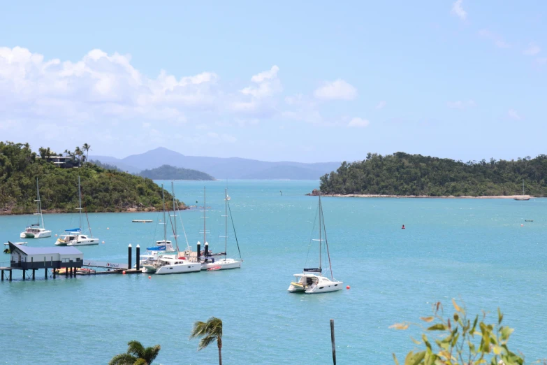 several boats floating on top of a blue body of water