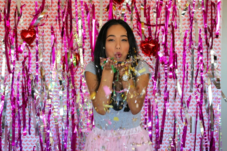 a person taking a picture in front of pink streamers and decorations