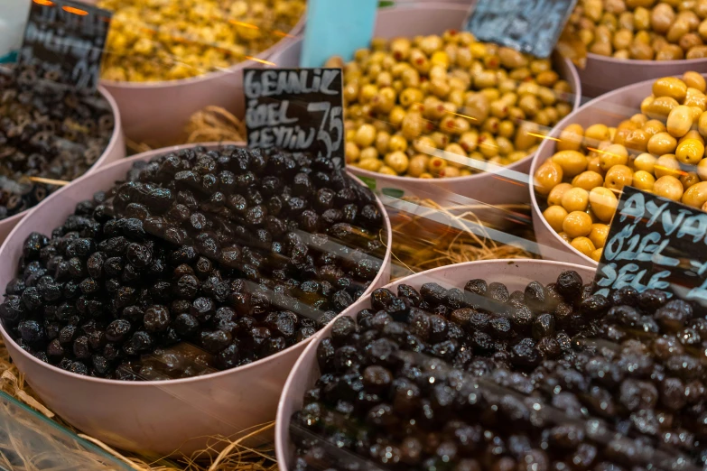 gs, plums and other fruits sitting in bowls for sale