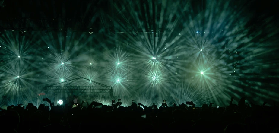 fireworks bursting in the air as people stand on the stage