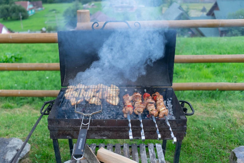 someone is cooking  dogs on an outdoor grill