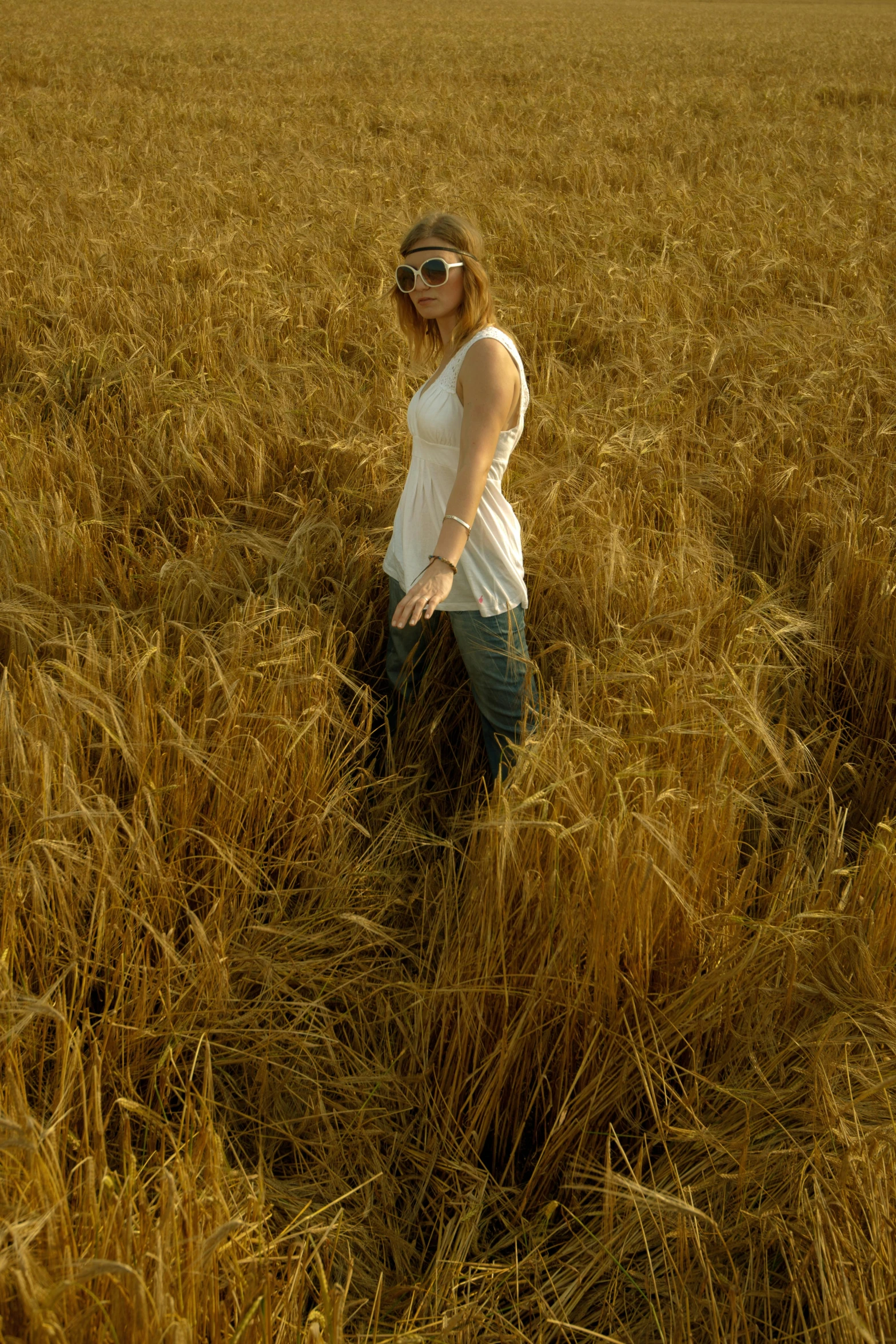 woman in a field standing among tall, golden grass