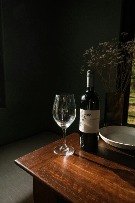 a glass and a bottle of wine on a table