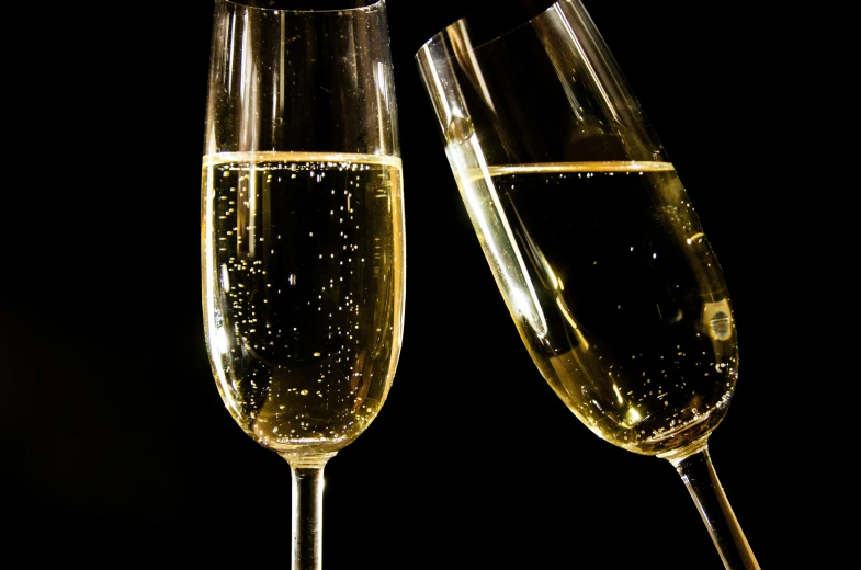 two wine glasses with sparkling bubbles next to each other