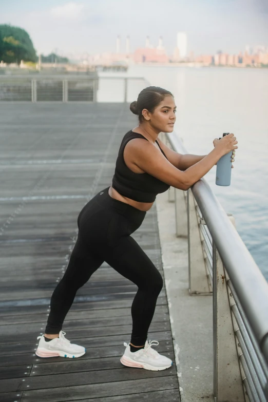 a woman standing on a pier next to water