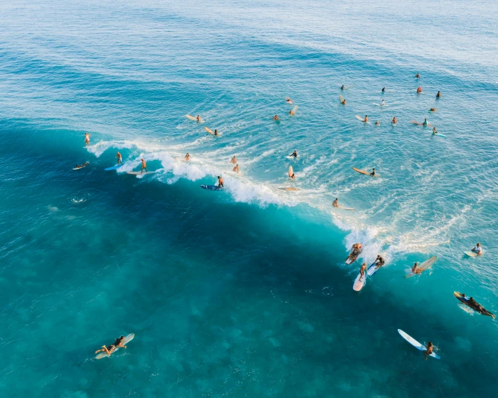 many people are surfing on a wave in the ocean