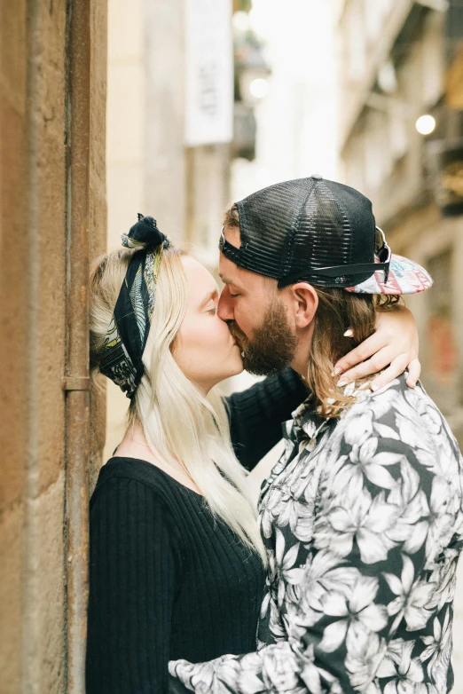 a man and woman kissing while standing together