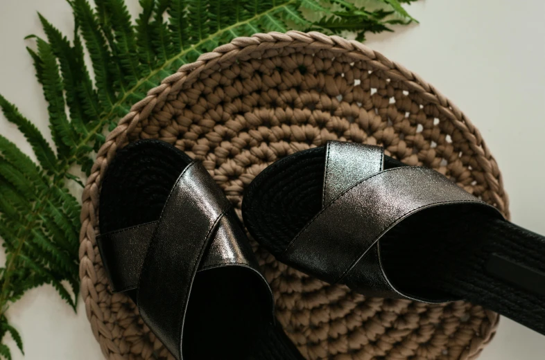 two black heels sitting on top of a rug