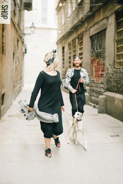 two people walking down a street with a dog and a man in costume