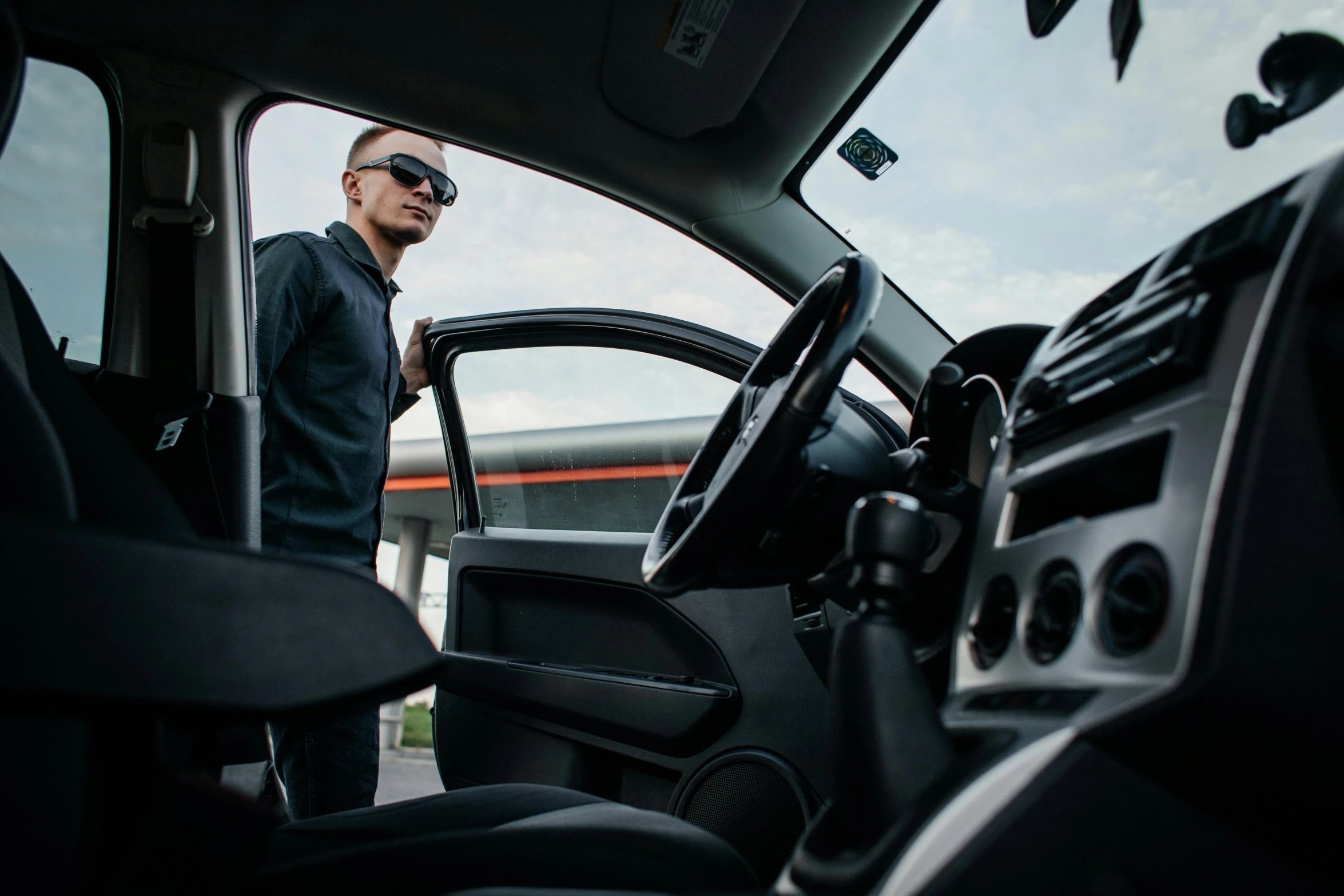 a person wearing sunglasses standing inside of a vehicle