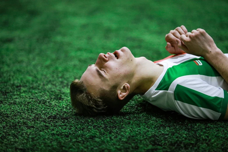 a man laying on top of a green field