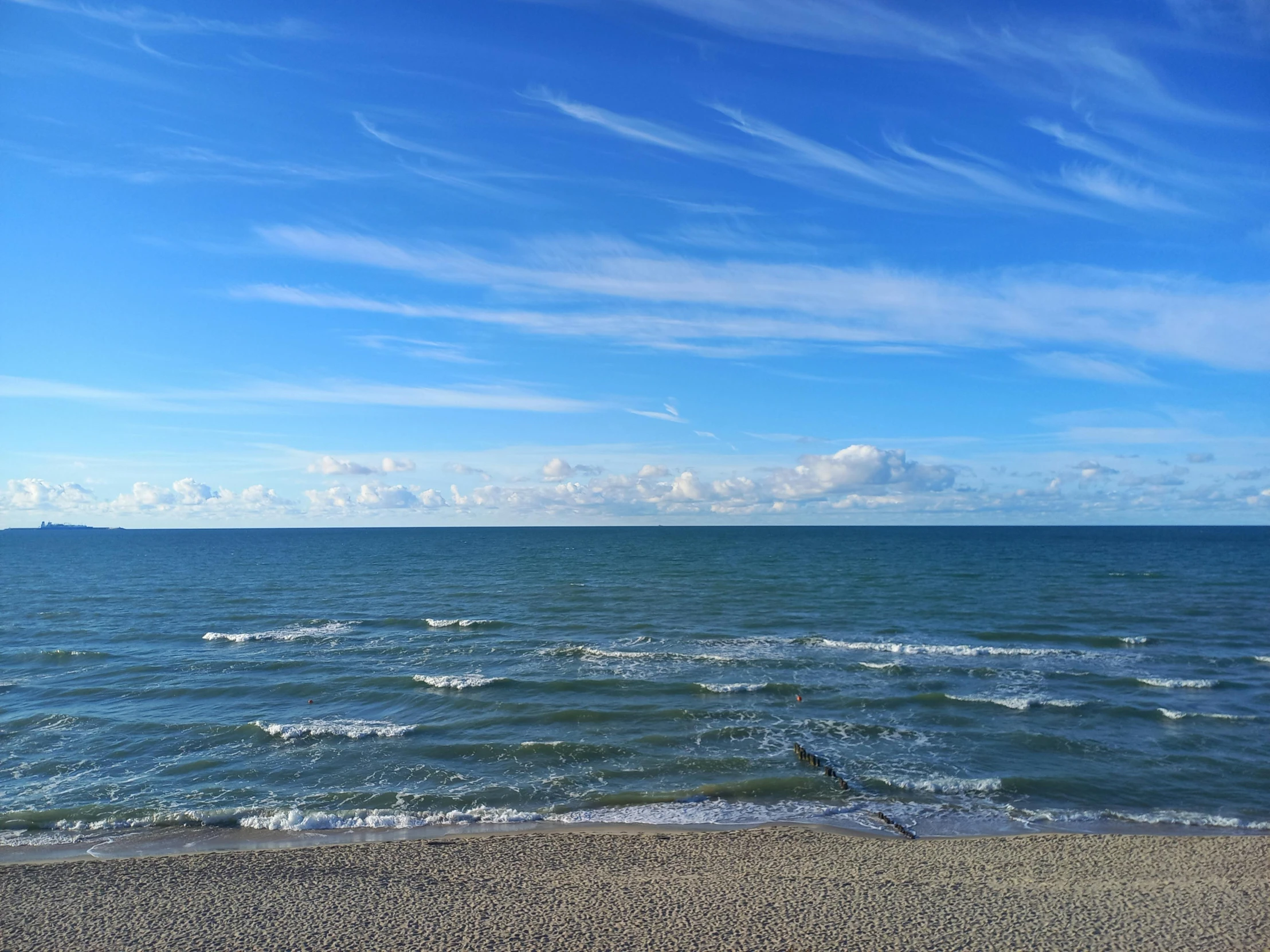 an ocean and beach scene on a clear day