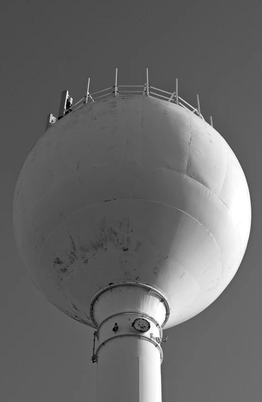 people are standing on the top of a large water tower