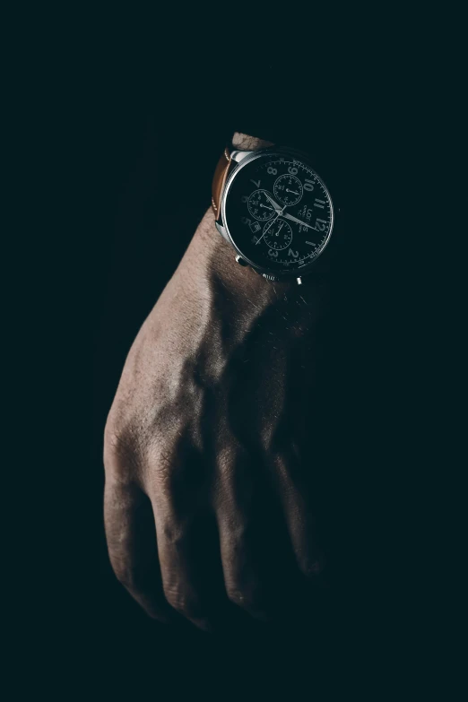 hand with wristwatch in dark space with darkness