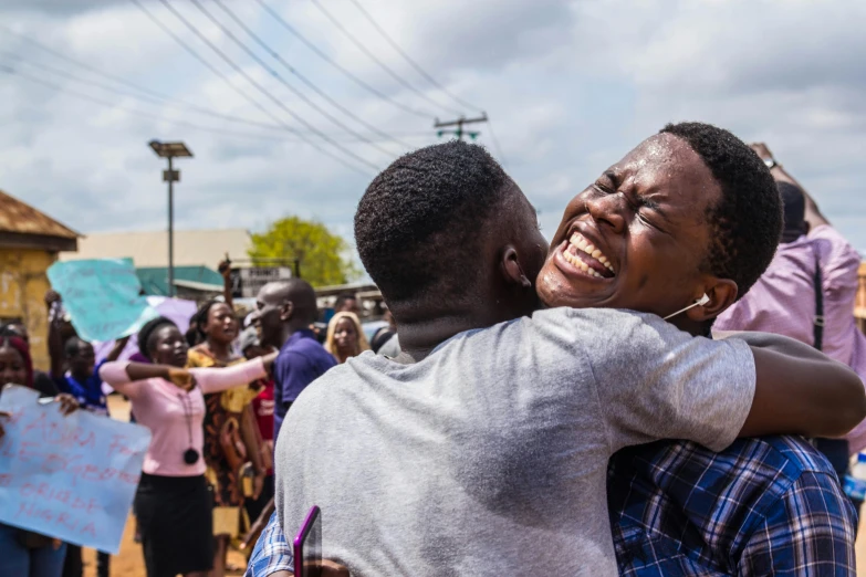 two people hugging each other in a group