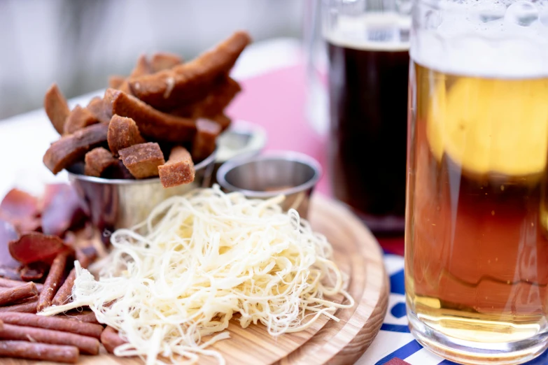 food on a plate next to a glass and some beer