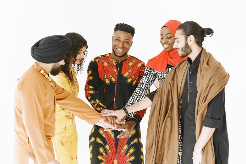 three men and two women dressed in african print clothes shake hands