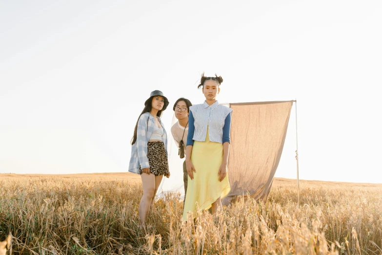 a man and two women standing in a wheat field