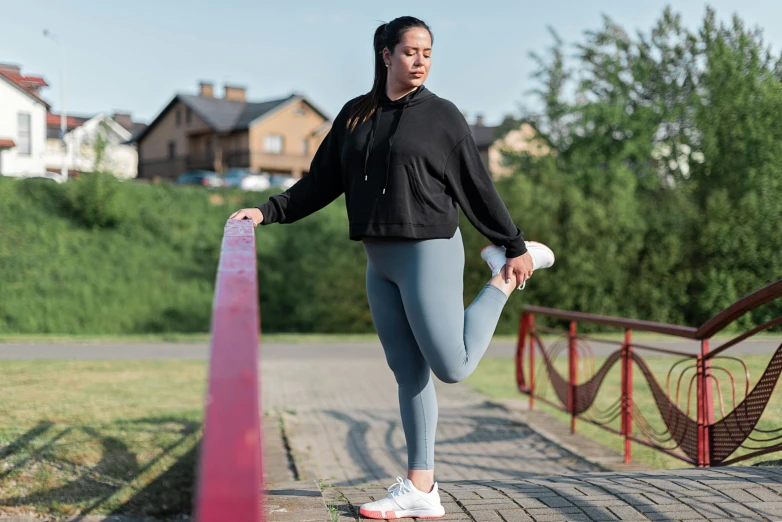 woman holding onto a red pole on the side of a road