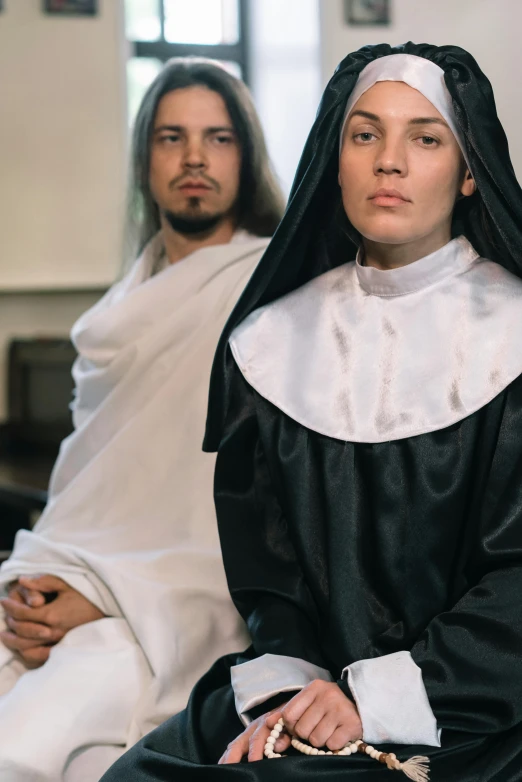 a man and woman in black robes with white clothes