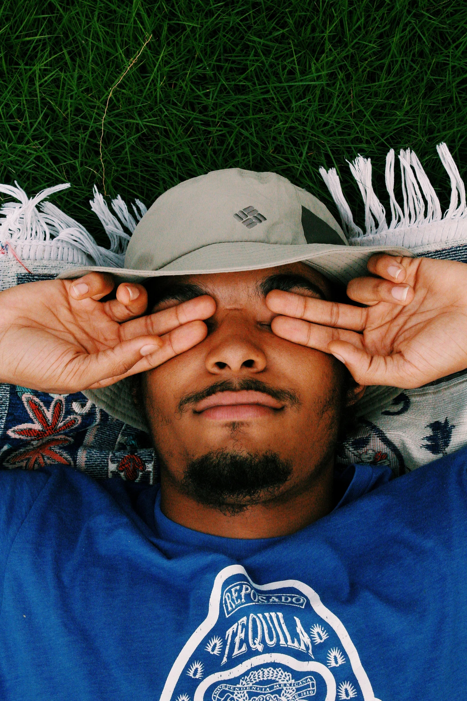 a man is covering his eyes on a blanket