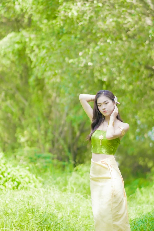 an attractive young woman in a green dress holding her head