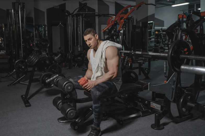 a man is sitting in the gym with heavy equipment