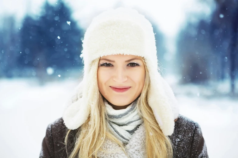 a beautiful blonde woman wearing a winter hat and scarf