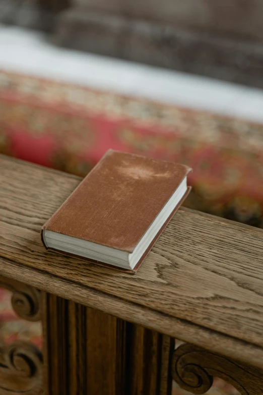 a brown book is on top of a wood bench