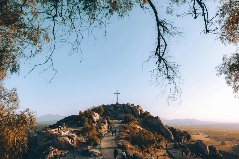 a cross is on a large rock with people in it