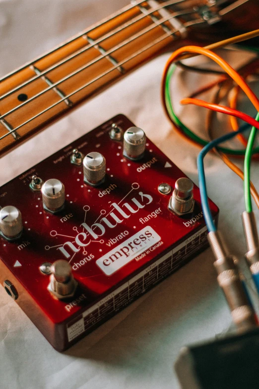 a red amp guitar with some colored wires next to it