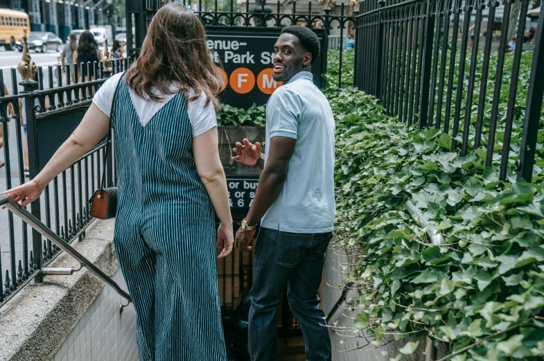 two people are standing outside on the side walk