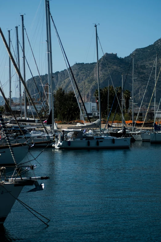 many white boats in the water near mountains