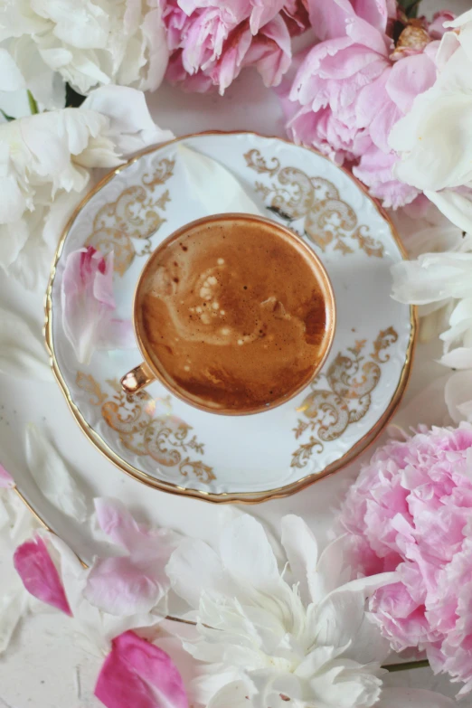 there is an empty plate and saucer on the table with flowers