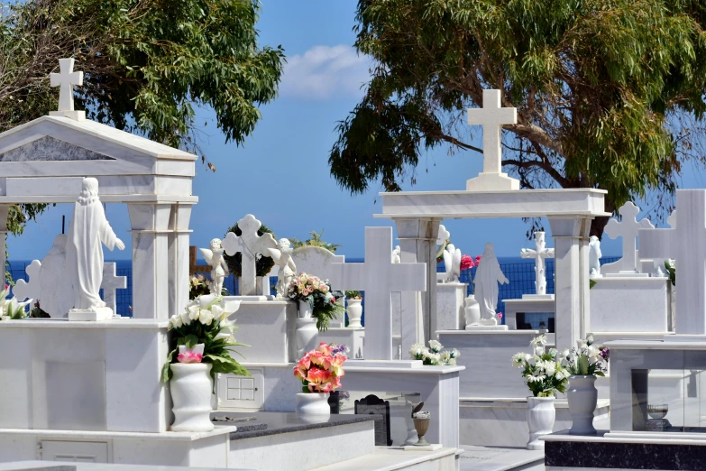 a bunch of white graves with flowers and crosses