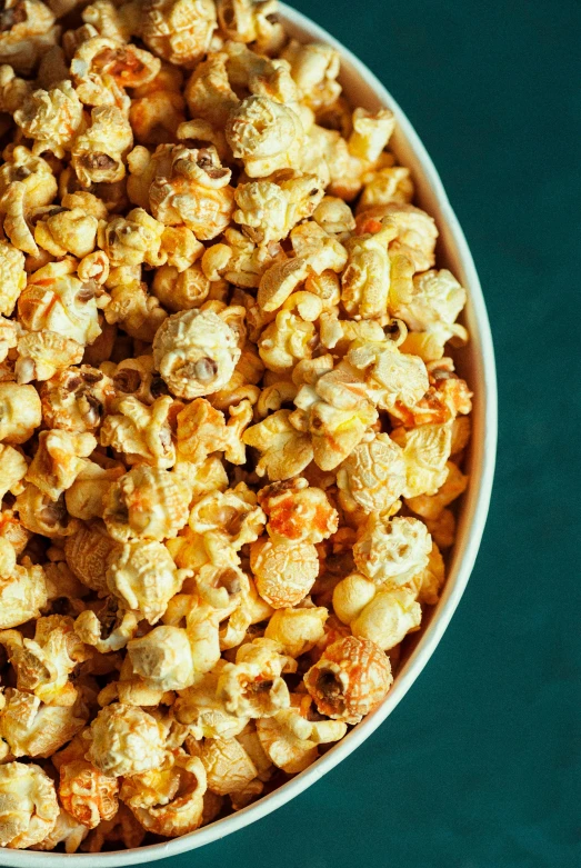 a bowl of popcorn sitting on top of a blue table